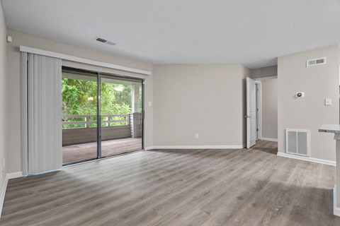 A room with a sliding glass door leading to a balcony.