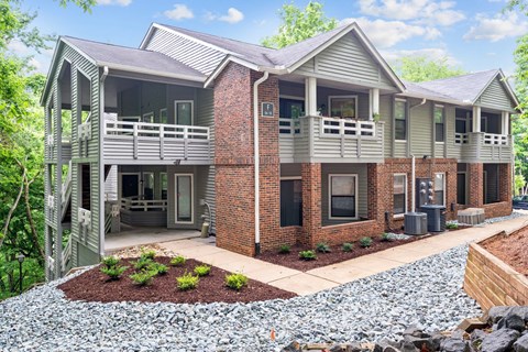 A two-story house with a balcony and a small garden in front.