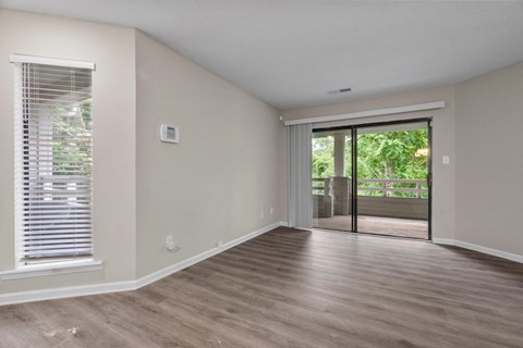 A room with a sliding glass door leading to a backyard.