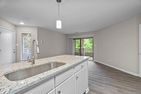 A kitchen with granite countertops and white cabinets.