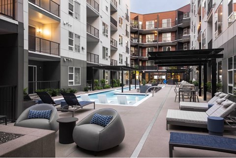 A large outdoor pool area with lounge chairs and a table.