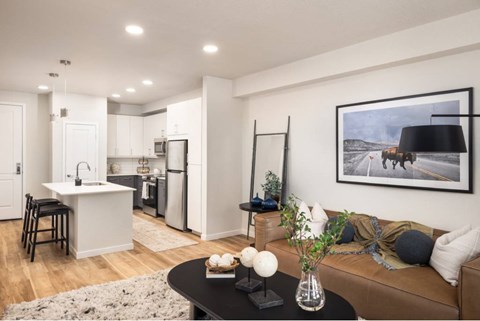 A modern kitchen with a dining table and a couch in the living room.