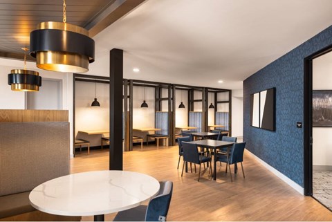 A modern dining room with a white table and blue patterned wall.