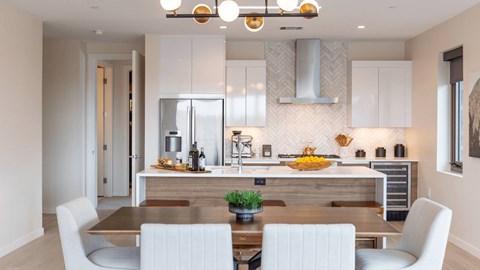A modern kitchen with a dining table and chairs.