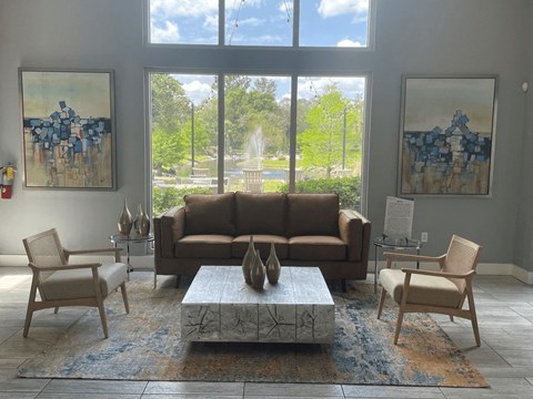 A living room with a brown couch, two chairs, and a coffee table.