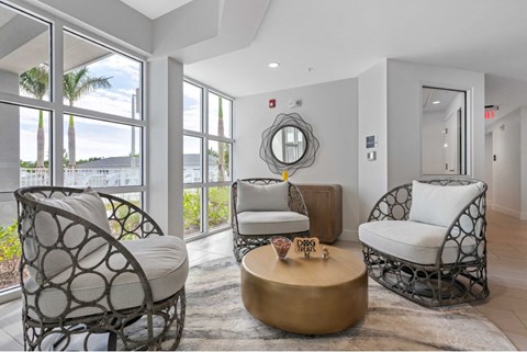A living room with a white chair and a gold coffee table.