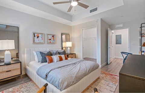 A bedroom with a bed, nightstand, and a rug.