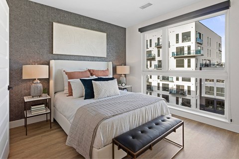 A bedroom with a large bed and a bench in front of it.
