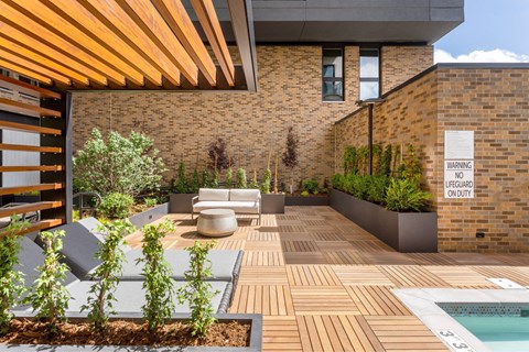 A modern backyard with a pool and a warning sign.