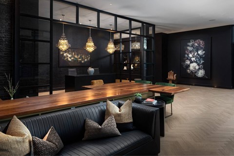 A modern living room with a black couch and a wooden table.