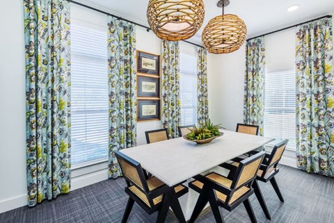 A dining room with a white table and chairs.