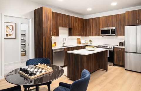 A kitchen with a black table and blue chairs.