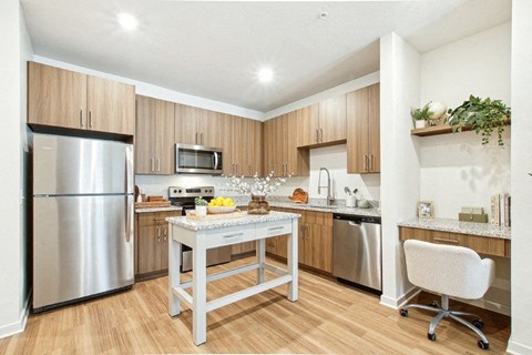 A kitchen with a table and a refrigerator.