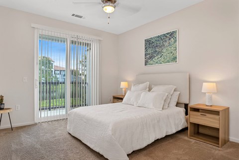 A bedroom with a large bed, a nightstand, and a painting on the wall.