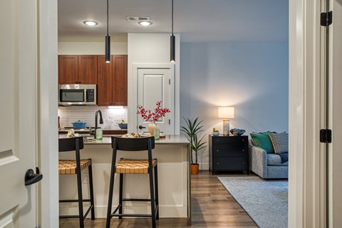 A kitchen with a table and chairs in front of a counter.