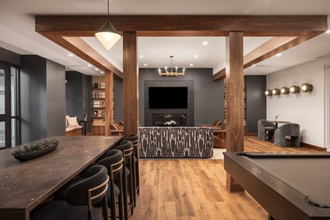 A modern living room with a pool table and a bar area.