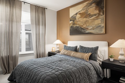 A bedroom with a large bed and a painting on the wall.