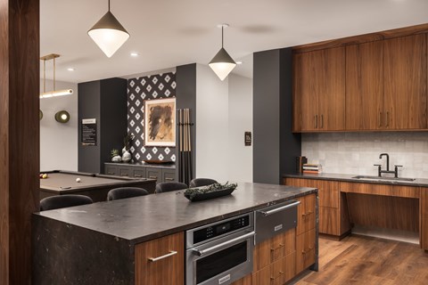 A modern kitchen with dark wood cabinets and a black countertop.