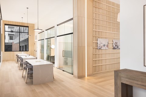 A modern dining room with a long table and chairs.