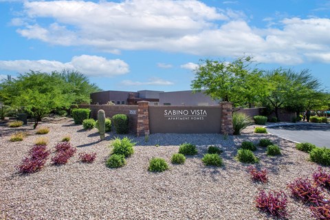The image shows a building with the name "SABINO VISTA APARTMENT HOMES" on it.