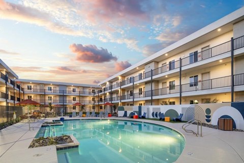 A large swimming pool in the middle of a courtyard surrounded by apartment buildings.