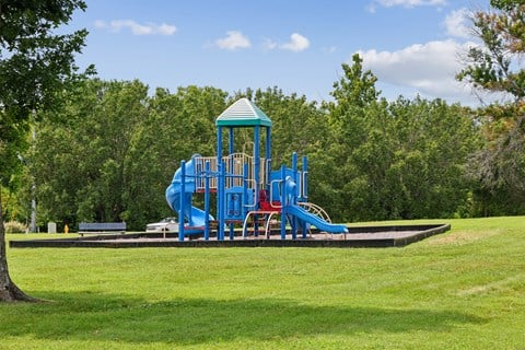 A playground with a blue slide and a green roof.