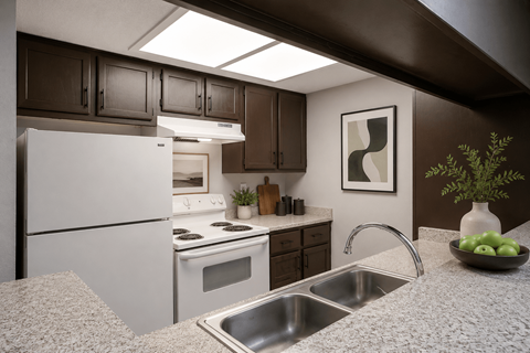A kitchen with a white fridge, stove, and sink.
