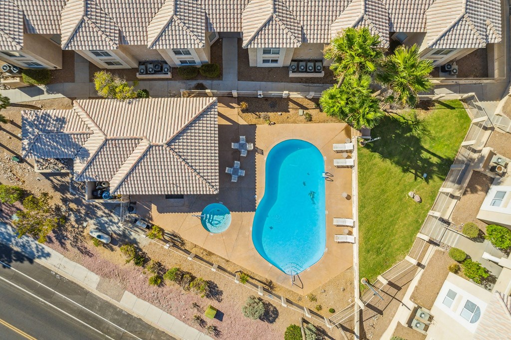 an aerial view of a swimming pool in front of a house