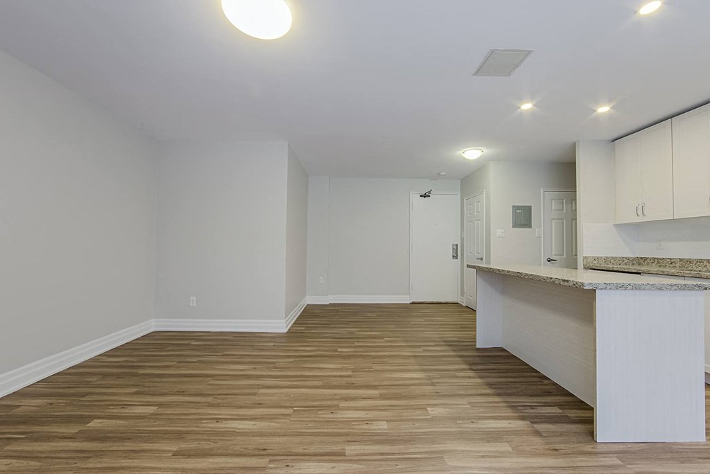 a living room and kitchen with white walls and wood floors at 107 Redpath, Toronto, CA
