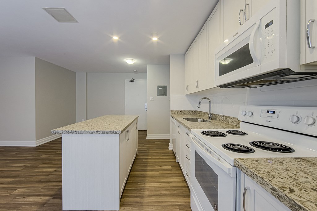 a kitchen with white appliances and granite counter tops and white cabinets at 107 Redpath, Canada