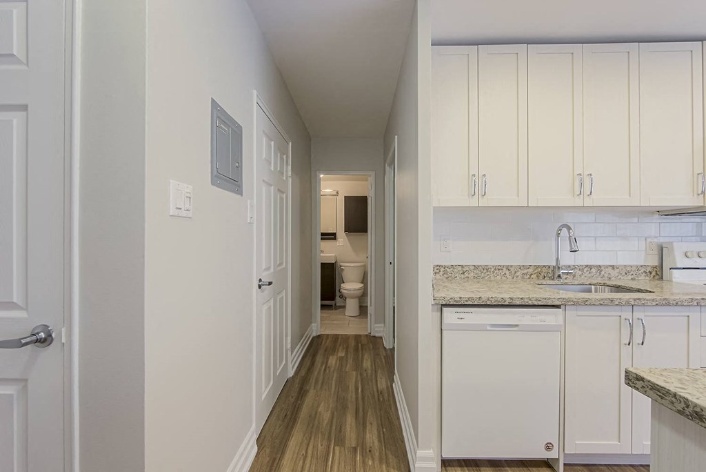 a kitchen with white cabinets and a sink and a hallway to a bathroom at 107 Redpath, Toronto CA
