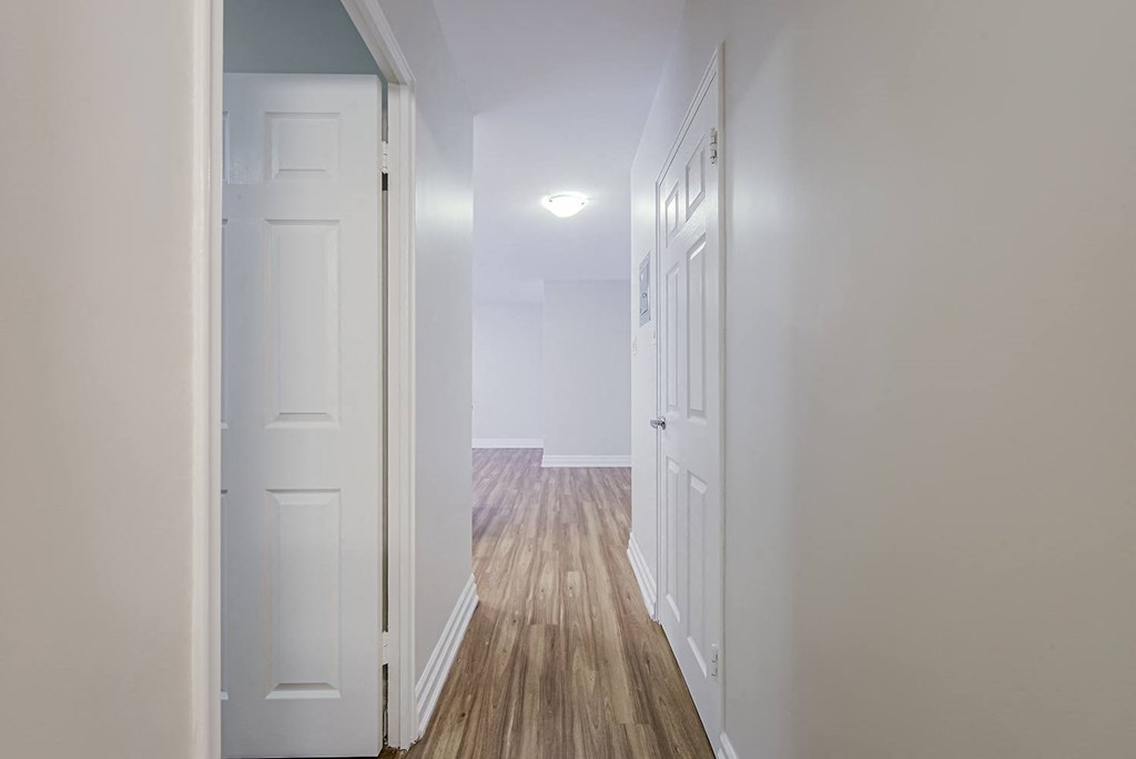 a hallway with white doors and white walls and wood floors at 107 Redpath, Toronto, M4S 2J9