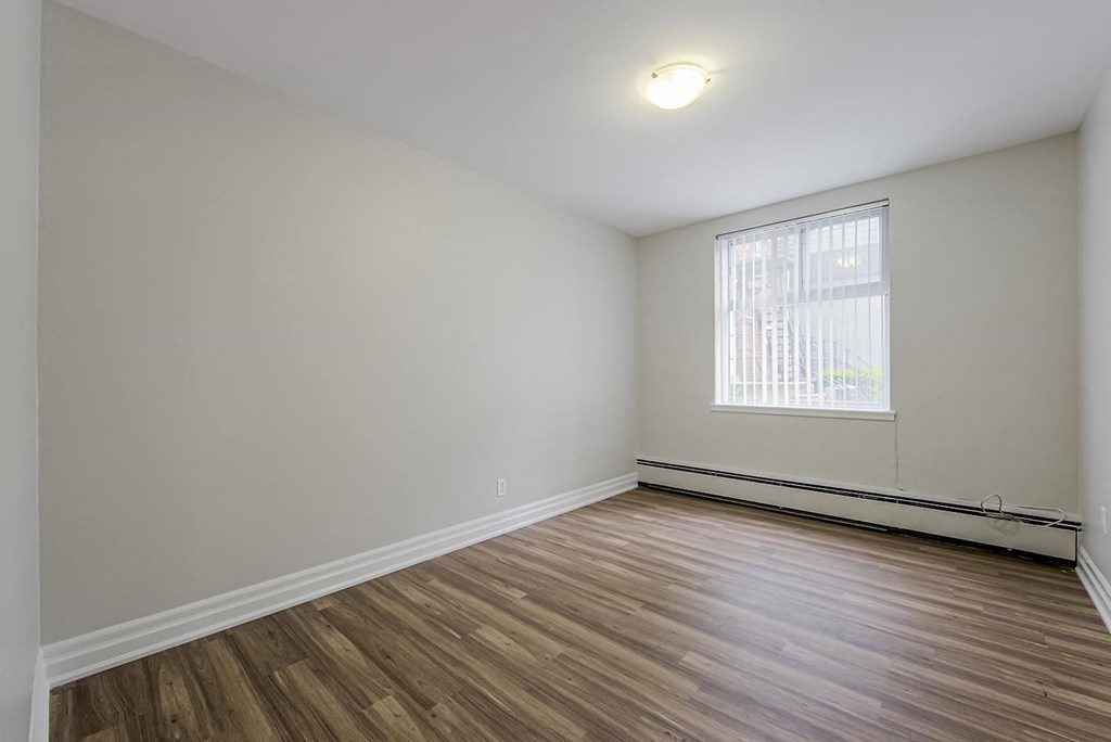 an empty living room with wood flooring and a window at 107 Redpath, Toronto
