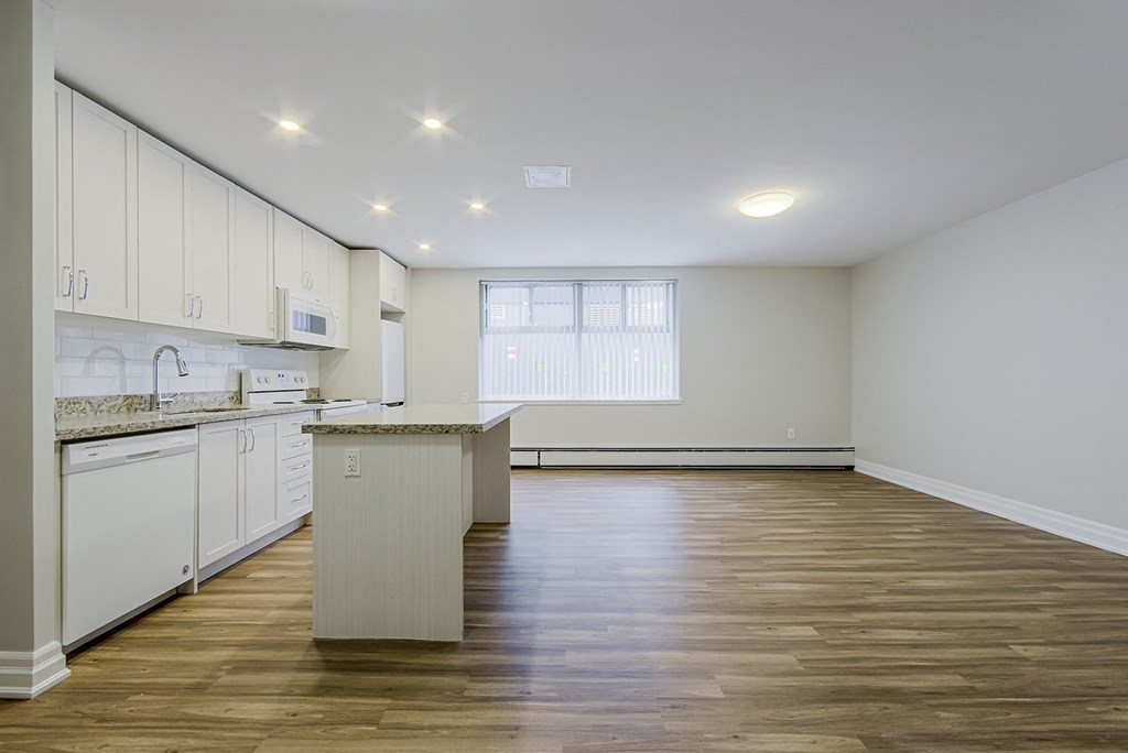 an empty kitchen and living room with white cabinets and a counter top at 107 Redpath, Toronto, CA M4S 2J9