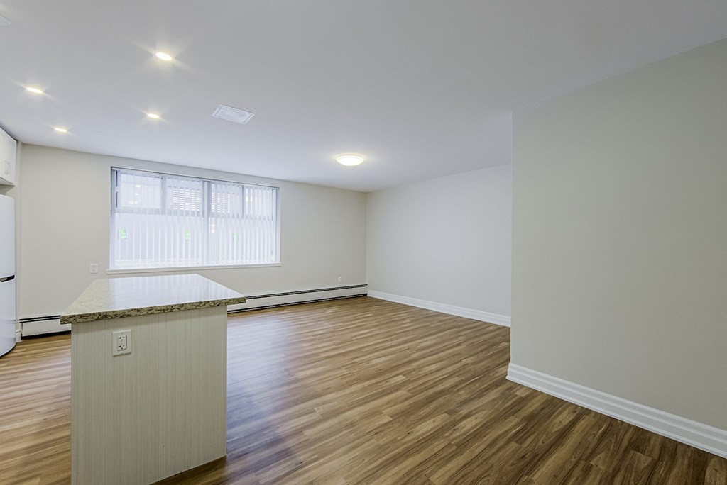 the living room and kitchen of a new home with wood flooring and white walls at 107 Redpath, CA