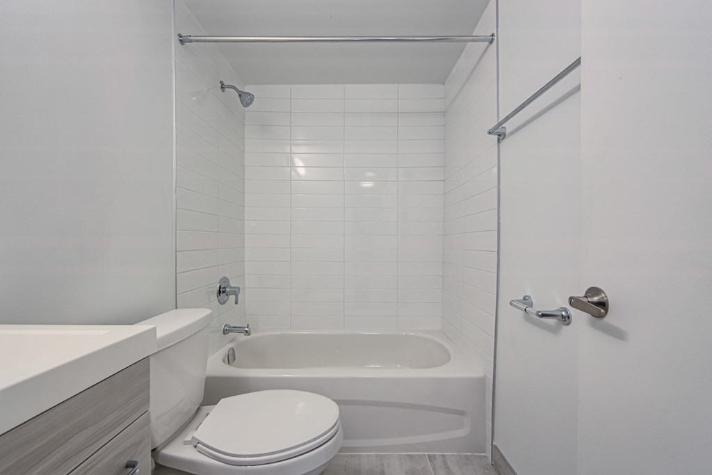 a white bathroom with a tub and a toilet and a sink at 111 Cosburn, East York Ontario