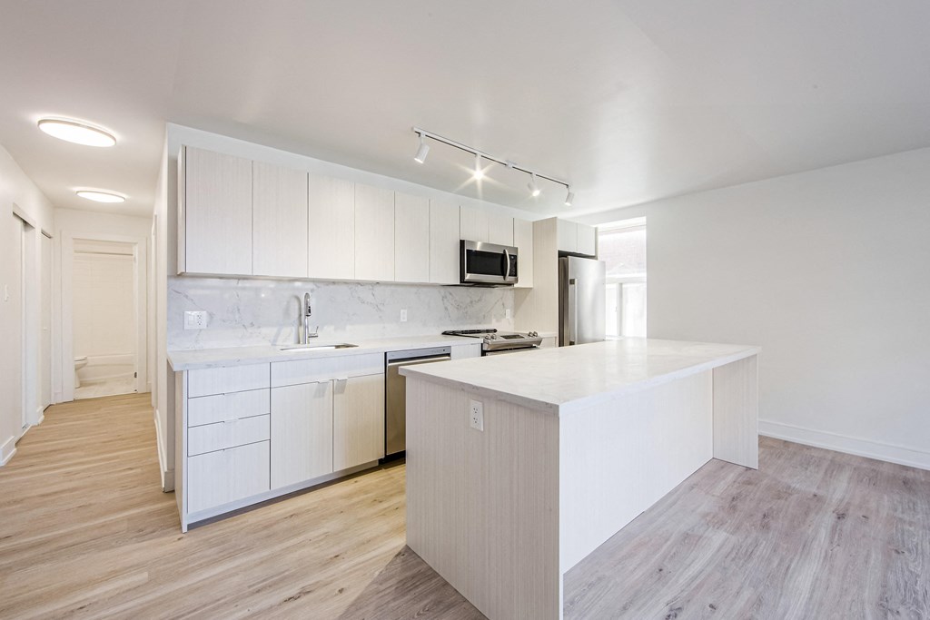 a large white kitchen with white cabinets and a white counter top at 111 Cosburn, Ontario, M4J 2L1