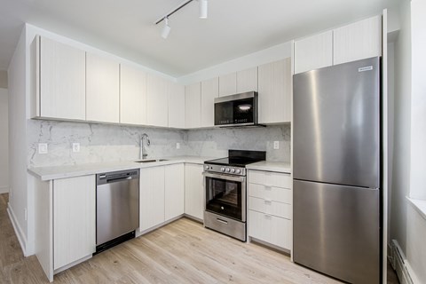 A kitchen with white cabinets and stainless steel appliances.