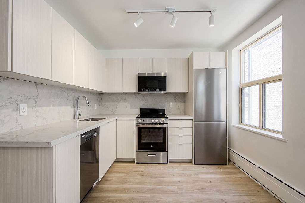a kitchen with white cabinets and stainless steel appliances at 111 Cosburn, Ontario, M4J 2L1