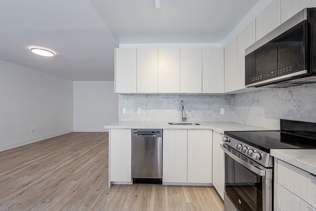 an empty kitchen with white cabinets and stainless steel appliances at 111 Cosburn, East York Ontario