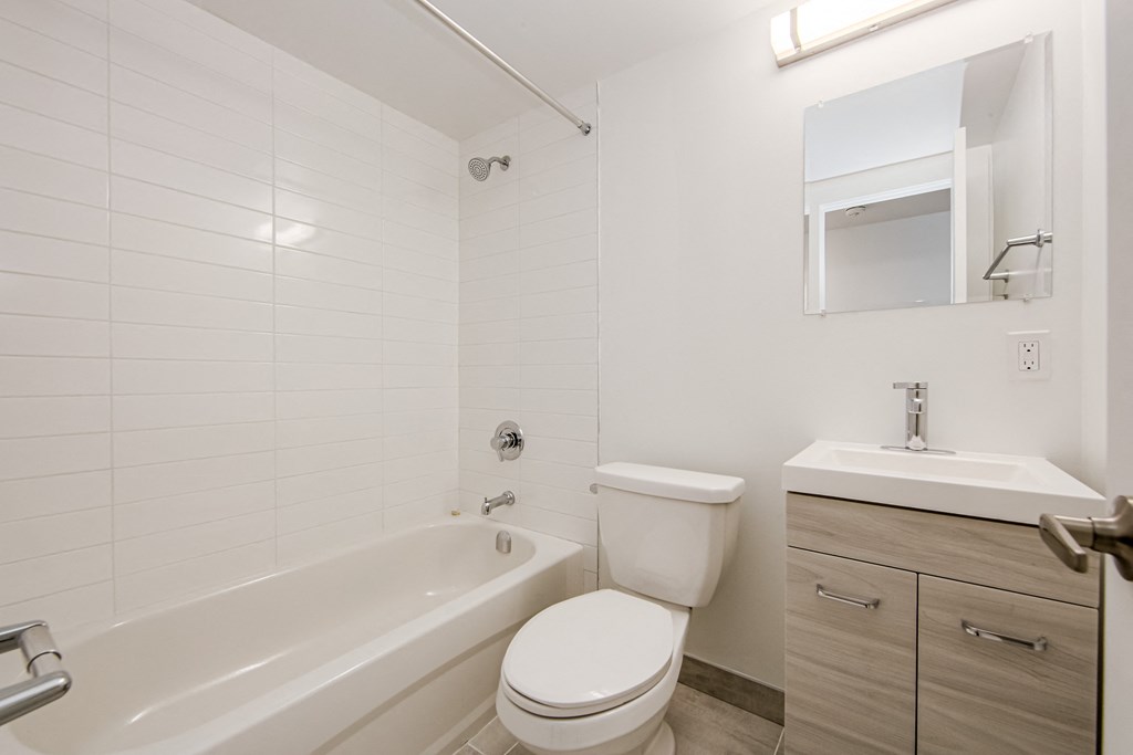 a bathroom with a toilet and a tub and a sink at 111 Cosburn, East York, ON