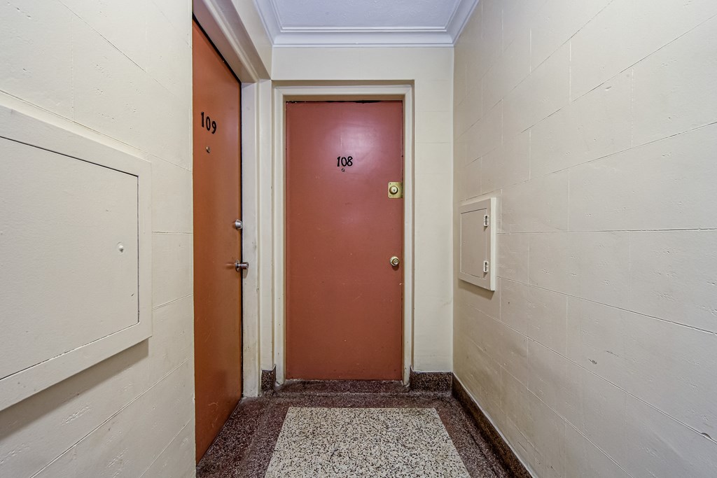 a door in a hallway of a building with a red door at 111 Cosburn, East York, ON M4J 2L1