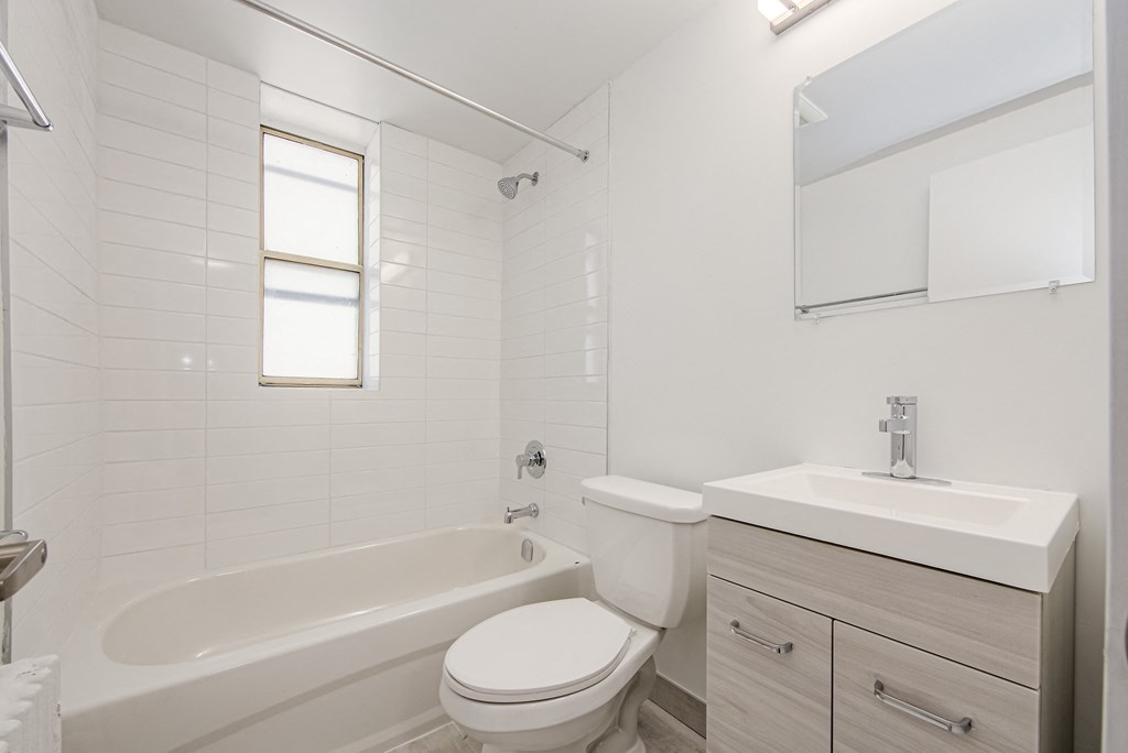 a white bathroom with a toilet sink and tub at 111 Cosburn, Ontario