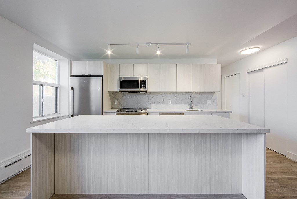 a white kitchen with white cabinets and a white counter top at 111 Cosburn, East York, M4J 2L1