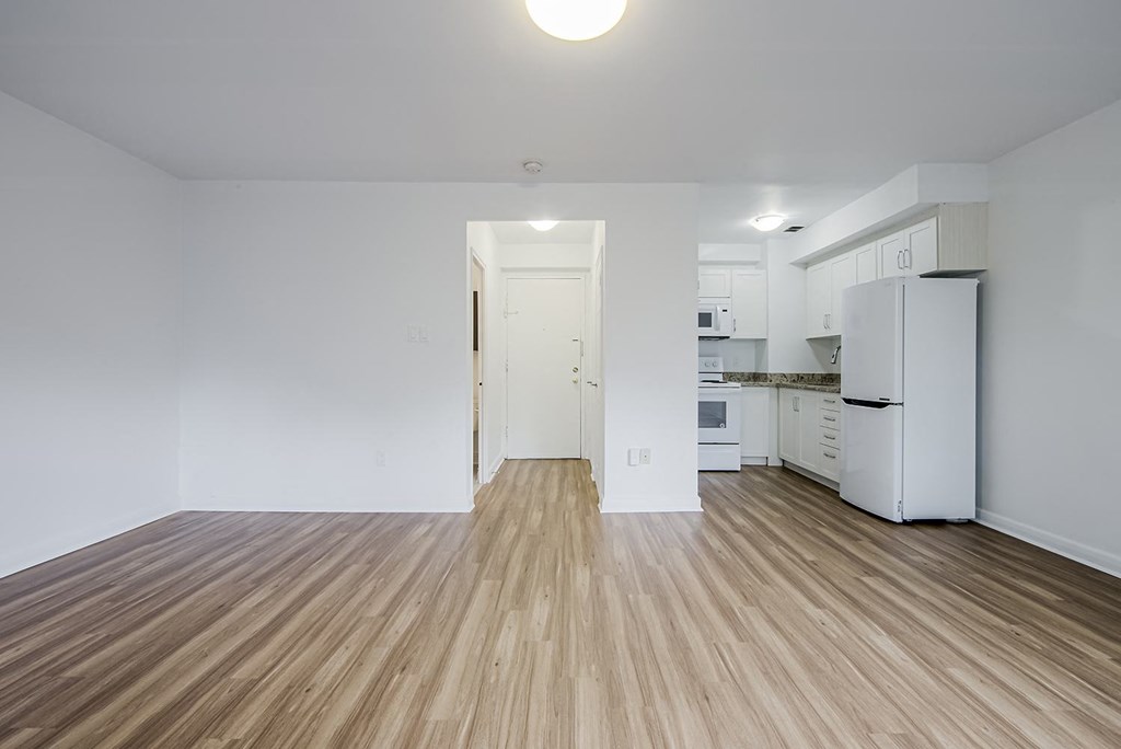 a living room and kitchen with a refrigerator and wood floors at 161 St. George, Toronto