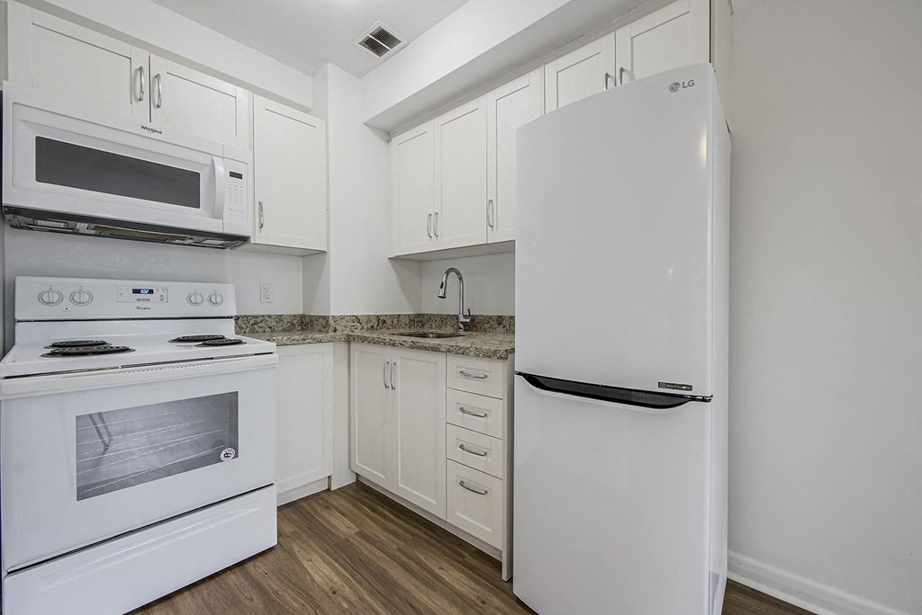 a white kitchen with white appliances and white cabinets at 161 St. George, Canada, M5R 2M3