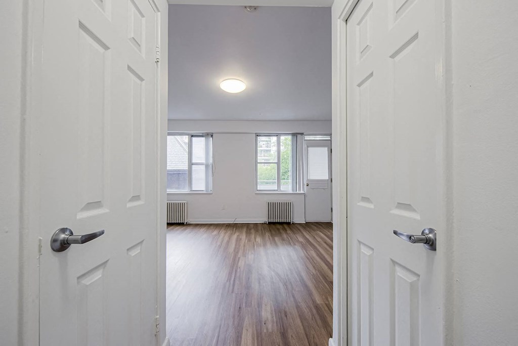 an empty living room with white walls and wood floors at 161 St. George, Toronto, CA M5R 2M3