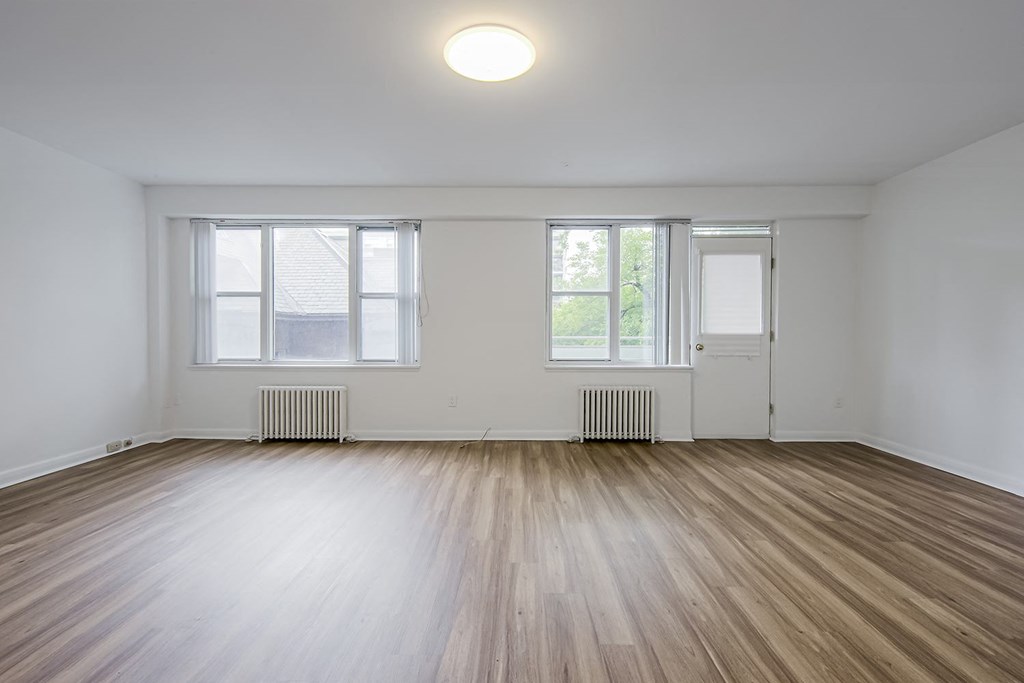 an empty living room with wood floors and white walls at 161 St. George, Canada