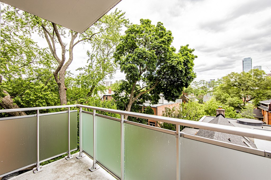 a balcony with trees and a city in the background at 161 St. George, Toronto, M5R 2M3