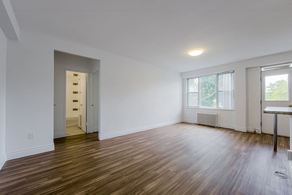 a living room with wood floors and a door to a hallway at 161 St. George, Canada, M5R 2M3